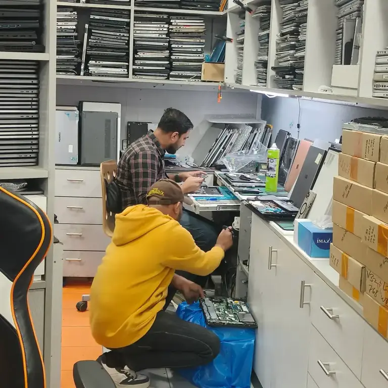 KCROC technician working on a laptop in the Hawalli repair laboratory